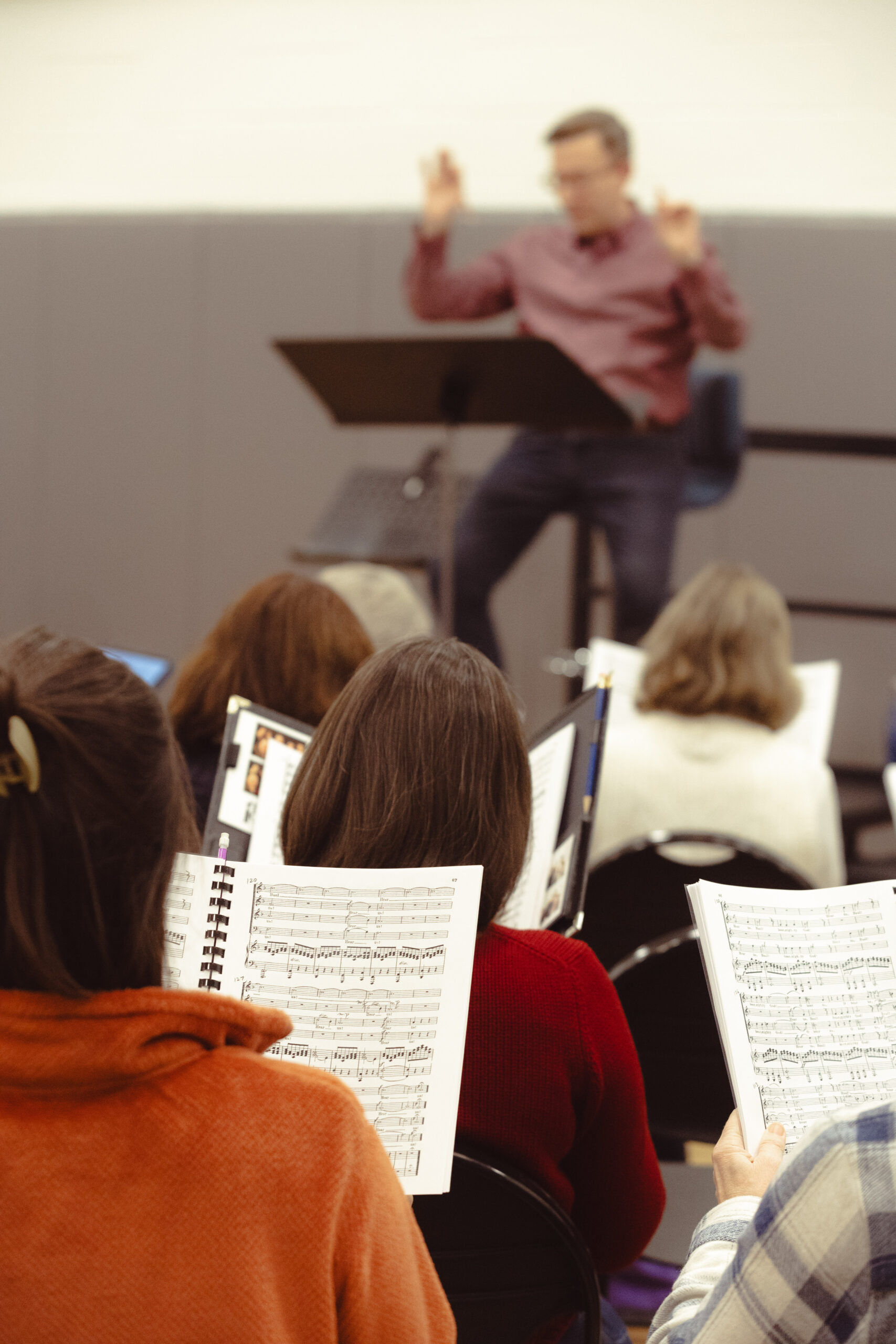 Tower Chorale singers reading music and rehearsing, under the direction of Patrick Godon